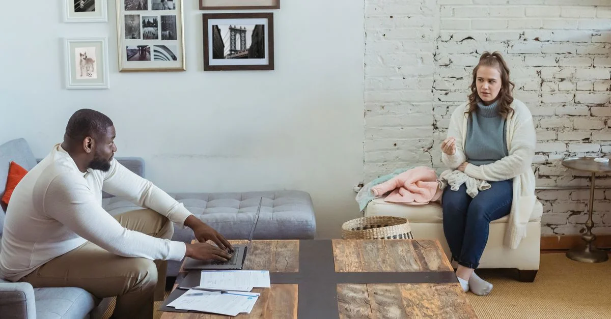 Un couple engageant une conversation sérieuse et émotionnelle dans leur salon.