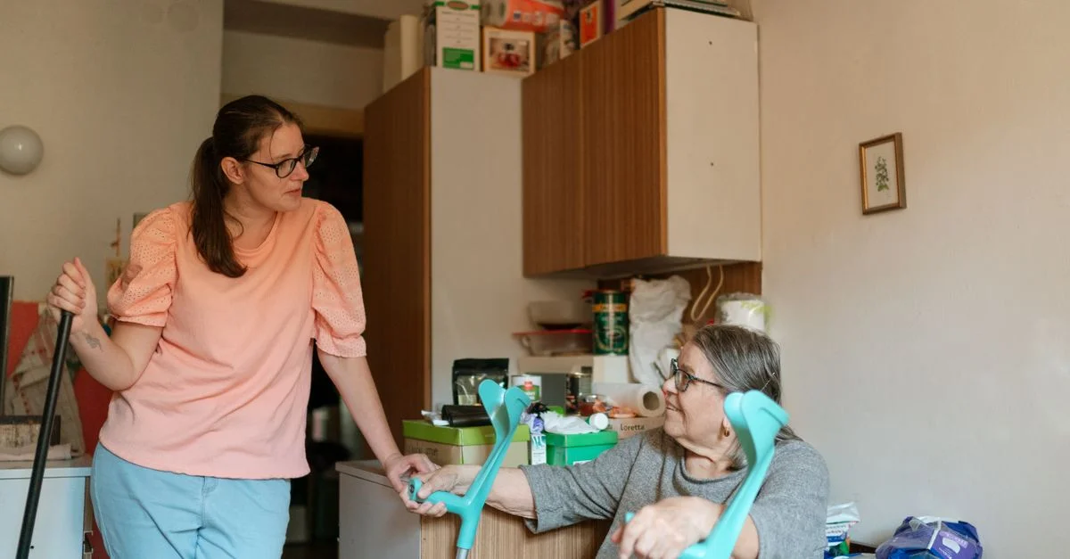 Un soignant s'occupant d'une personne âgée utilisant des béquilles dans un environnement familial confortable à Prague.