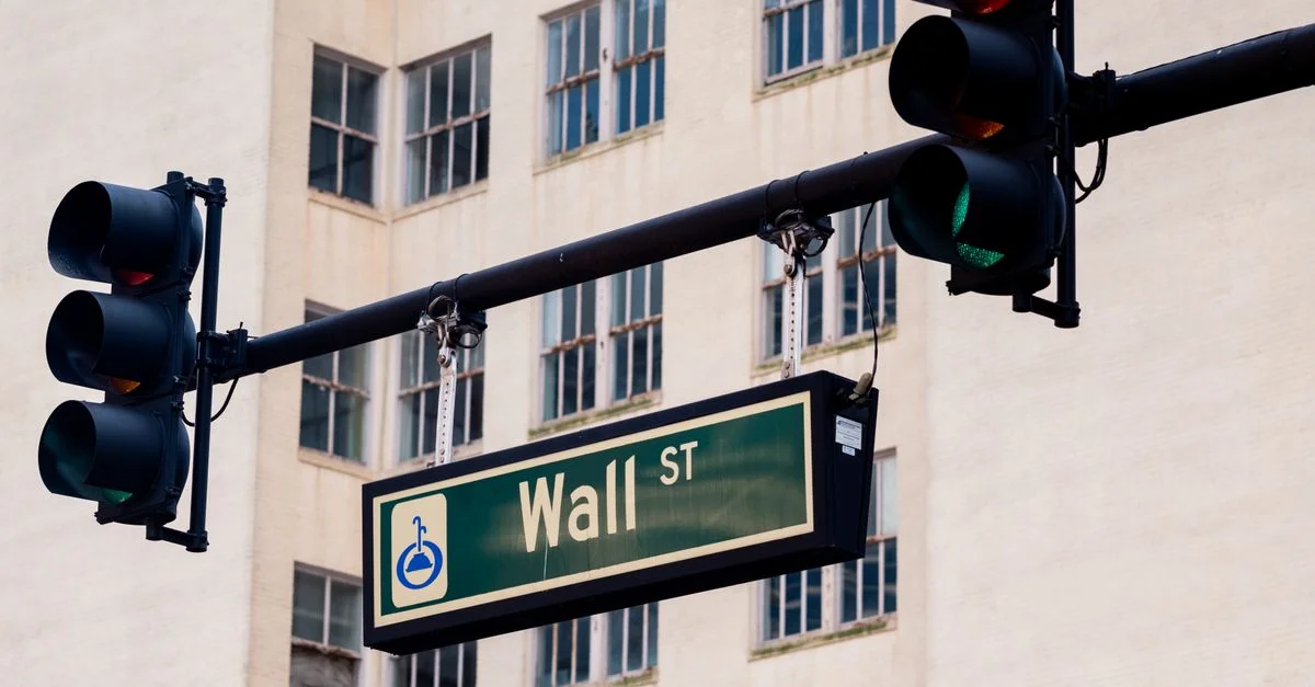 Feux de circulation et panneau Wall St dans un paysage urbain, symbolisant le centre financier.
