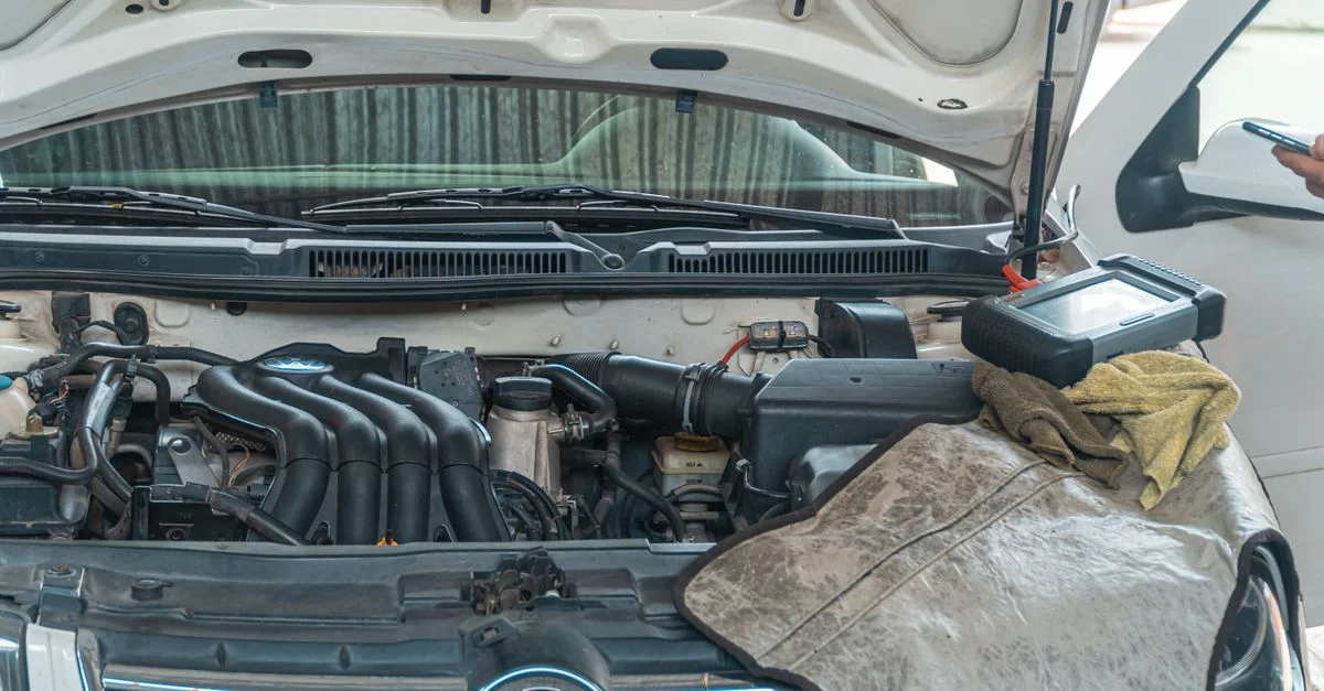 Gros plan d'un moteur de voiture Volkswagen en réparation dans un garage, avec des outils et de l'équipement de diagnostic en cours d'utilisation.