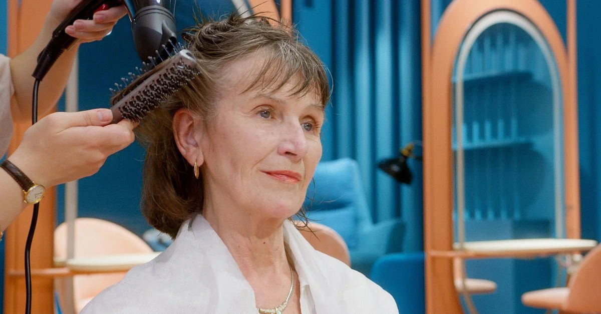 Une femme senior bénéficie d'une coiffure et de soins dans un salon moderne.