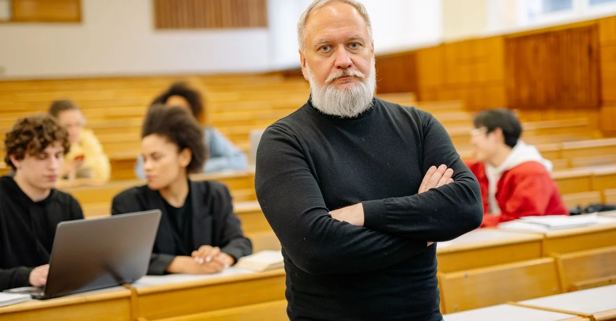 Professeur confiant dans un amphithéâtre avec des étudiants variés engagés dans l'apprentissage.